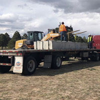 Image of a truck delivering concrete blocks from binblocks.net, showing the offloading process.